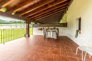 An outdoor patio with a table and chairs, a pergola, and a view of a green landscape. - Family Villa Uitzenea with Garden, Near San Sebastián and Pamplona (Gorriti)