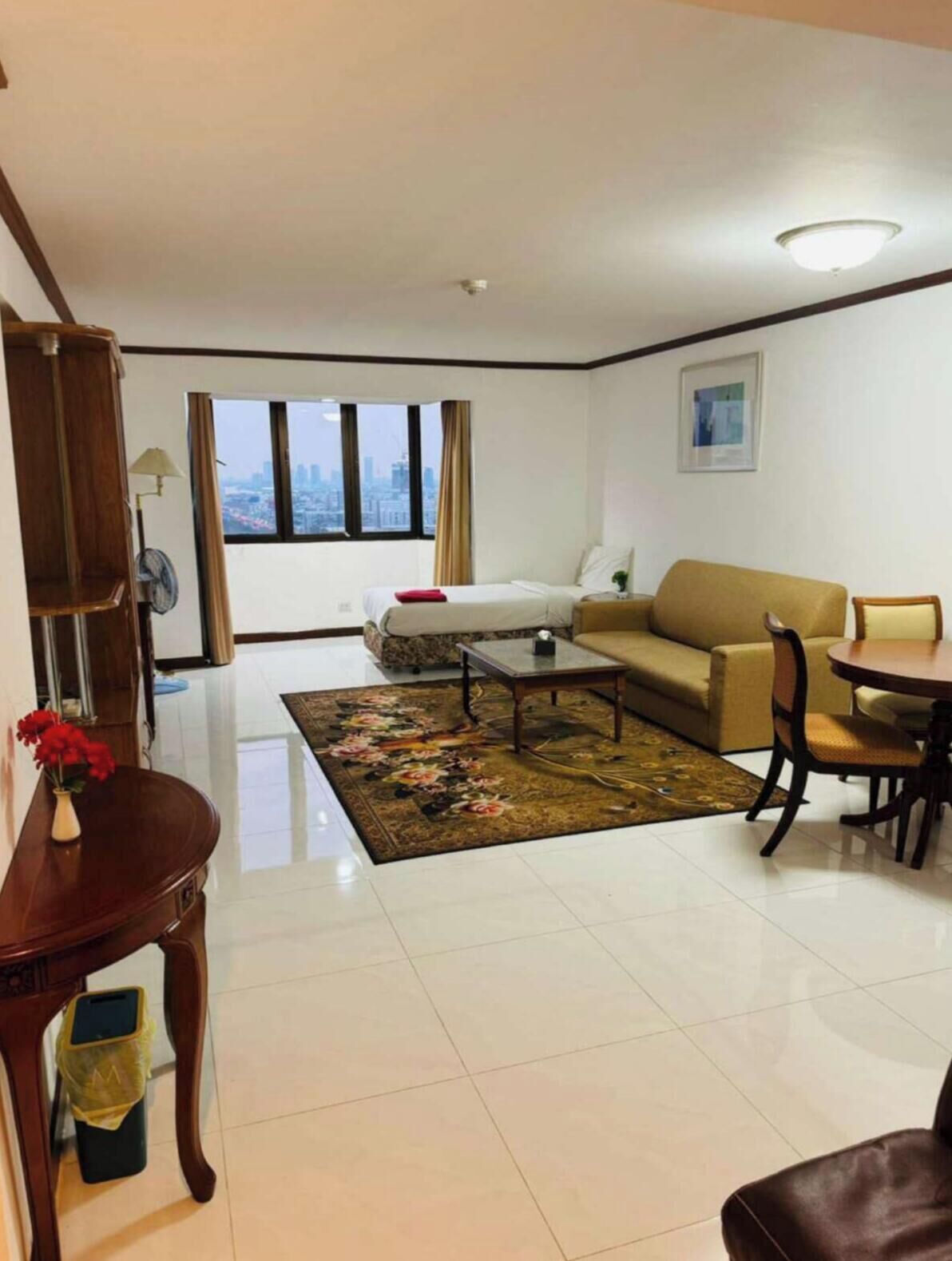 A modern living room with a sofa, coffee table, and a dining table with chairs.