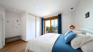 A bedroom with a bed, a bench, a window with curtains, and a view of greenery outside. - Villa Kostrena in a green oasis by Villas Guide (Kostrena)
