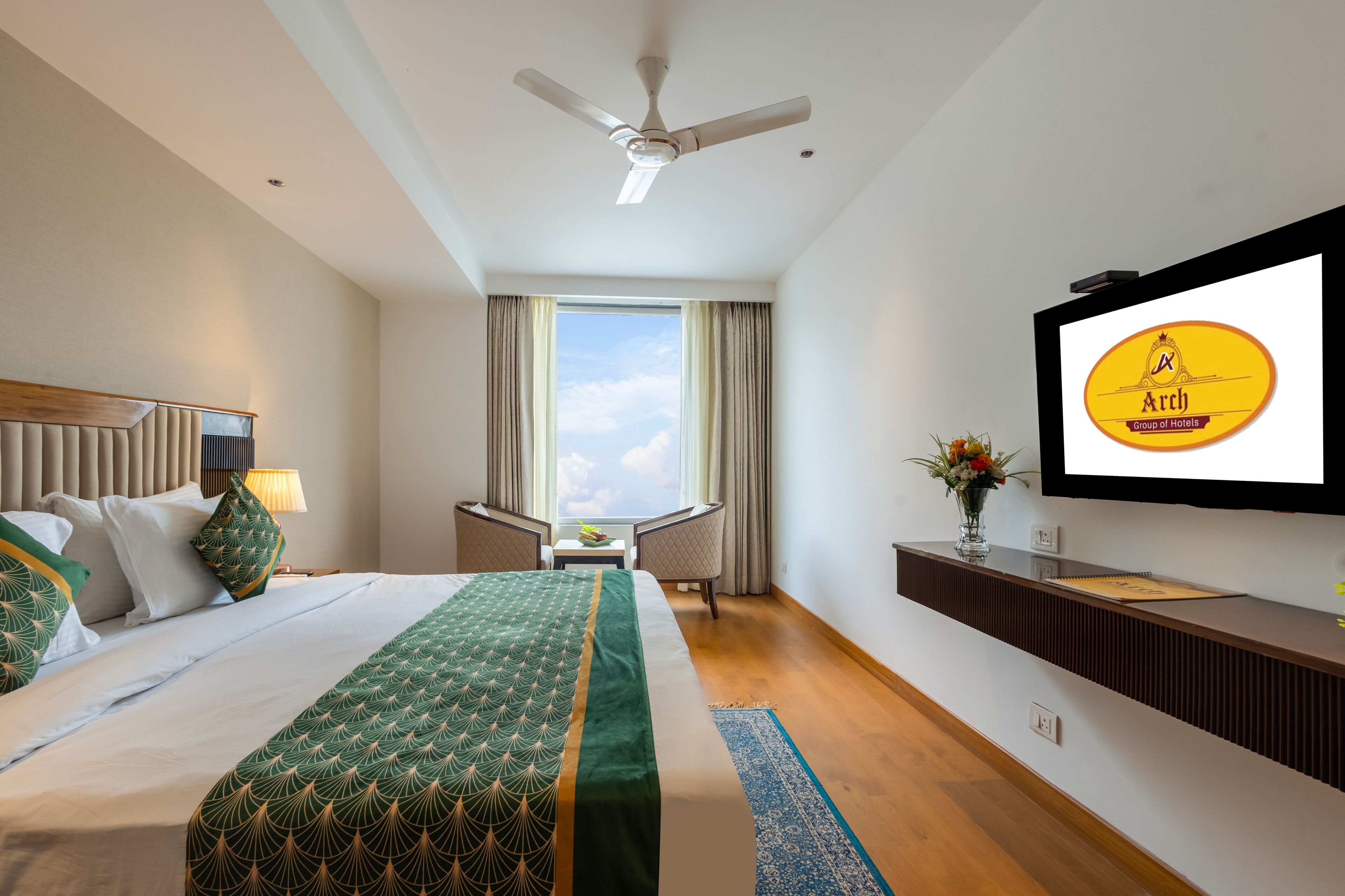 Une chambre d’hôtel équipée d’un lit, d’un bureau, d’une chaise, d’une télévision et d’une fenêtre avec des rideaux.