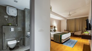 A hotel room with a shower, toilet, bed, bedside table, and a TV. - The Lohias Premium - Delhi IGI Airport (New Delhi)