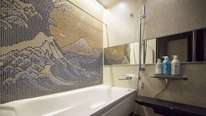 A modern bathroom with a large bathtub, a mosaic wall, and a shelf with toiletries.