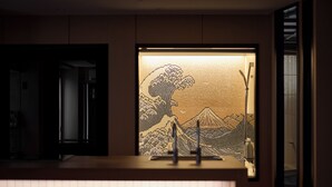 A modern kitchen with a bar area, a refrigerator, and a patterned window.
