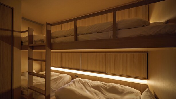 A bunk bed room with a wooden headboard and a ladder.