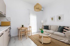 Una cocina moderna con armarios blancos, una mesa de comedor de madera y una mesa redonda con una revista.