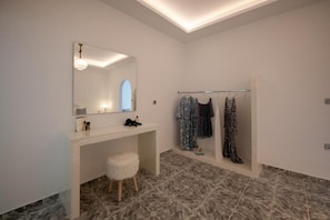 Un baño con tocador, espejo y perchero.