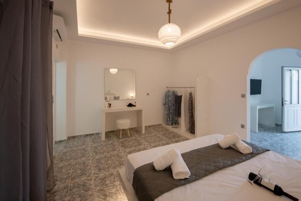 Una habitación de hotel moderna con cama, escritorio, espejo y zona de ducha.