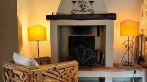 A rustic interior with a fireplace, wooden furniture, and a tiled floor. - Cottage with garden cave in the hills of Pietrasanta (Monteggiori)