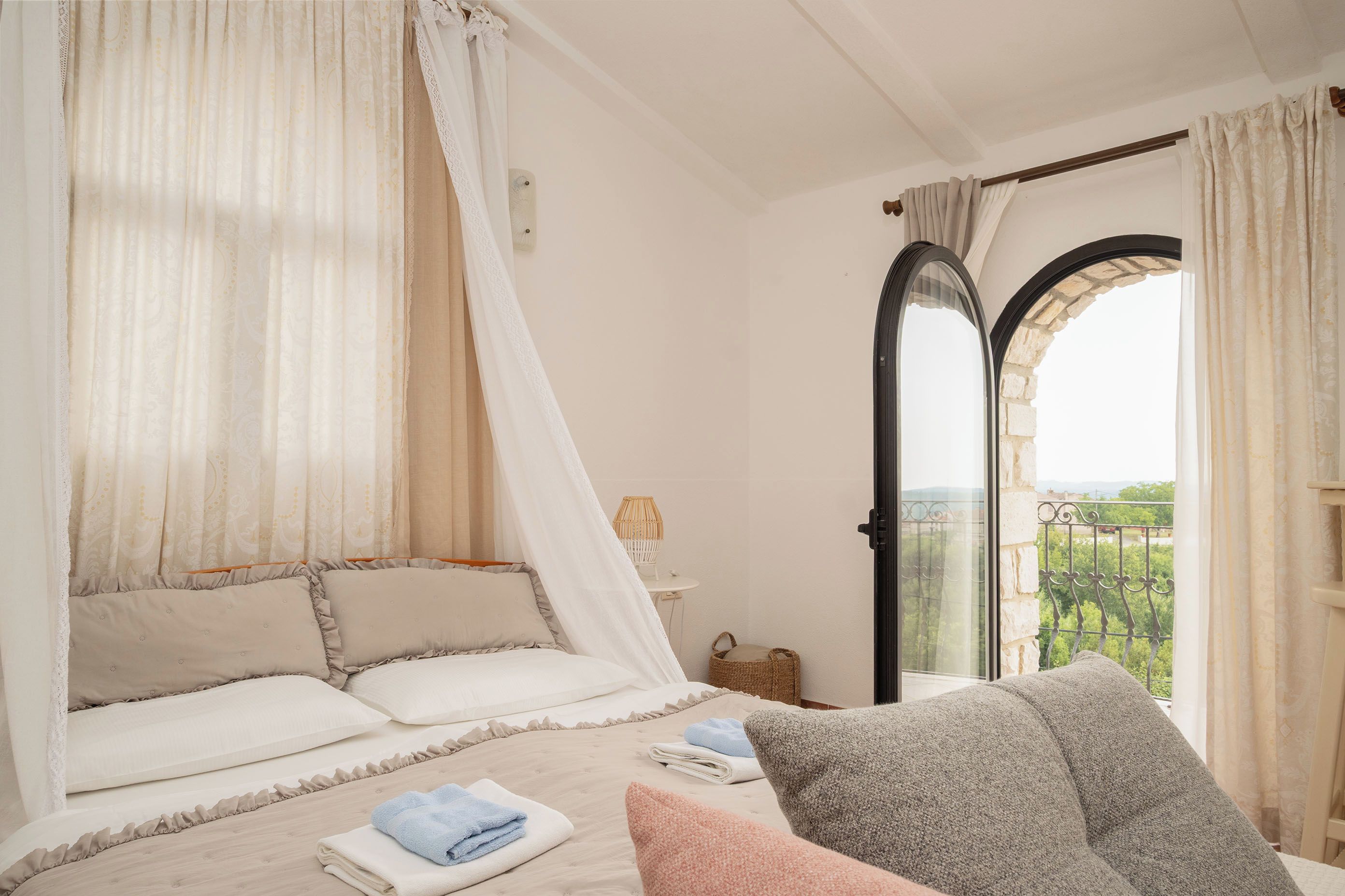Un dormitorio con cama, ventana con vistas y puerta.