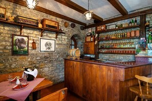 Eine rustikale Bar mit Holzböden, einer Steinsäule und einer Holztresen.