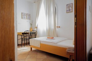 A bedroom with a bed, a desk, chairs, and a small table. - San Mauro (Momjan)