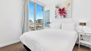Een hotelkamer met een groot bed, een nachtkastje, een lamp en een bloemschilderij.