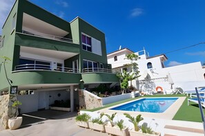 A two-story building with a pool, outdoor seating, and a clear blue sky. - Family villa Green House - Private pool - Garden - Tenerife North Bajamar (Bajamar)