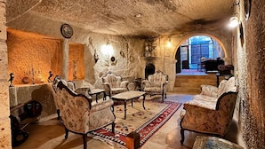 A cozy interior with stone walls, a fireplace, and traditional furniture.