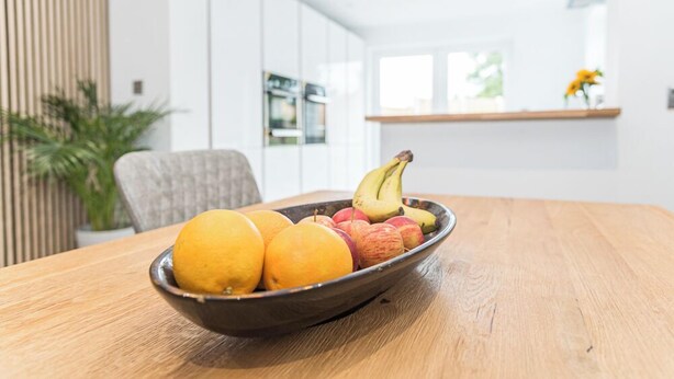 Una mesa de madera con un cuenco de fruta.