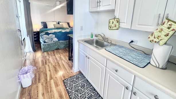 A compact kitchenette with a sink, cabinets, and a small countertop. - Delightful condo with AC in vibrant Honolulu perfect for your stay (Honolulu)