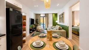 Un appartement moderne comprenant un coin repas, un salon et une kitchenette.