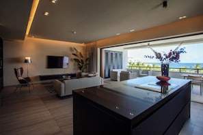 Una sala de estar moderna con un ventanal grande, un televisor de pantalla plana, un sofá y un comedor.