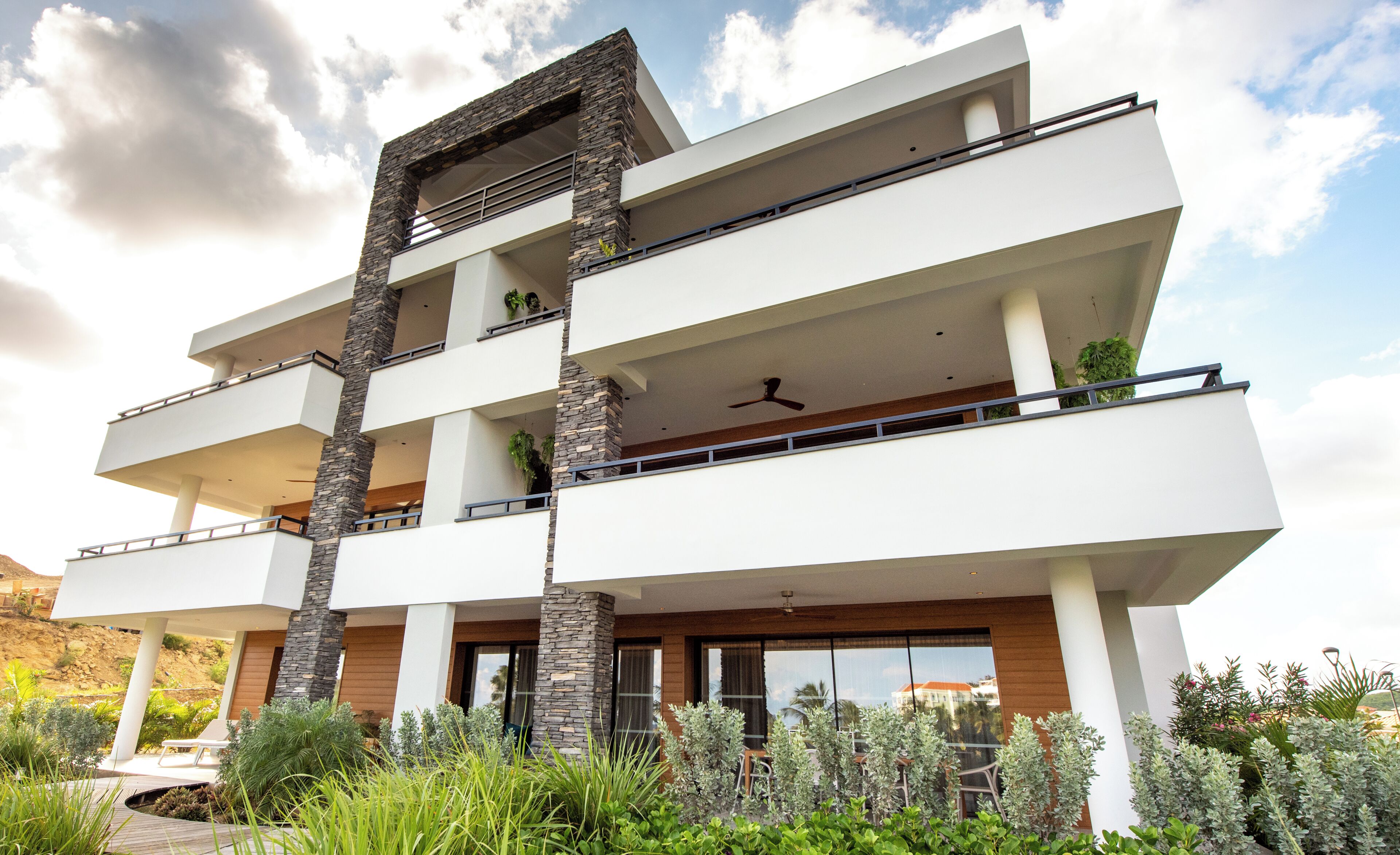 Un edificio de varios pisos con balcones, ventanas amplias y techo plano.