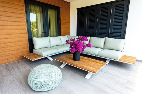 A modern living room with a sectional sofa, a coffee table, and a round ottoman.