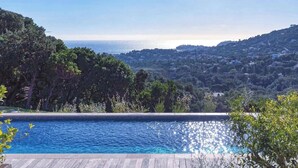 Ein Pool mit Blick auf das Meer und die Hügel.