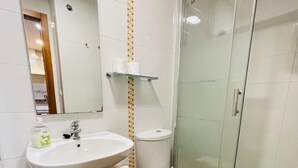 A bathroom with a sink, toilet, and glass shower enclosure. - Mountain Ski Apartment in San Isidro Ski Resort (Puebla de Lillo)