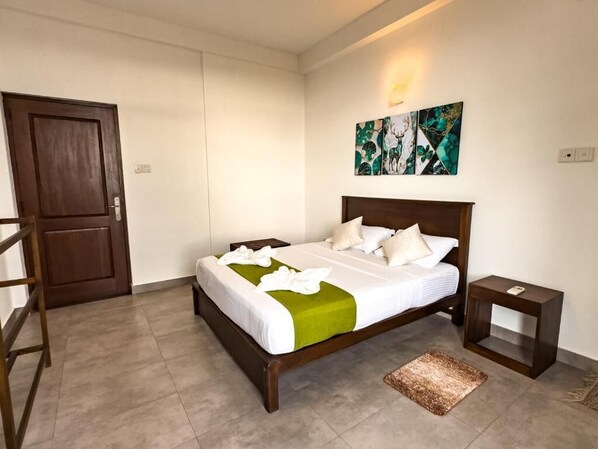 Un dormitorio con una cama, una mesita de noche, una puerta y un cuadro en la pared.
