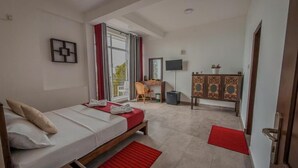 Una camera da letto con un letto, una scrivania, una sedia, una TV e un armadio.