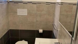 Une salle de bain avec des toilettes, un lavabo et un miroir.