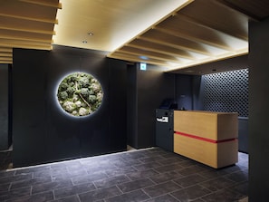 A reception area with a circular window, a reception desk, and a wall-mounted information kiosk. - TABI ASAKUSA (Tokyo)