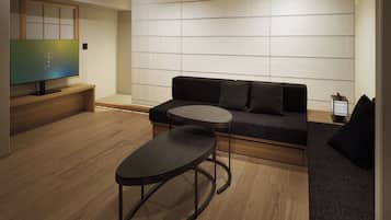A modern living room with a sofa, a coffee table, and a television.