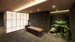 Een kamer met een houten bank, een groot shoji-scherm en een rotstuin met planten.