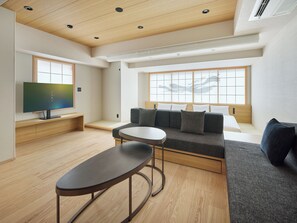 A modern living room with a sofa, a coffee table, and a TV.