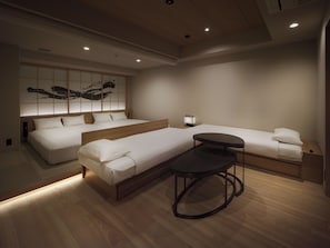 A modern hotel room with two beds, a small table, and a wall-mounted artwork. - TABI ASAKUSA (Tokyo)