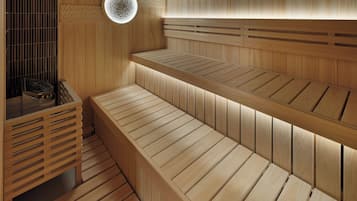 A sauna with wooden benches and a circular light fixture.