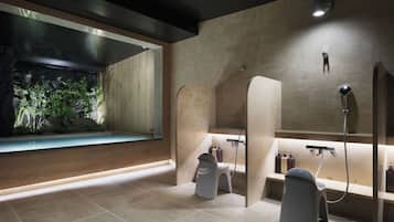 A modern bathroom with a large bathtub, a shower area, and a sink.