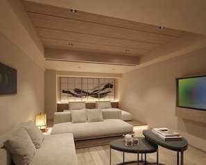 Una sala de estar moderna con un sofá, una mesa de centro y un televisor montado en la pared.