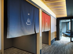 Una habitación de hotel con un ventanal grande, un sofá y suelo alfombrado.