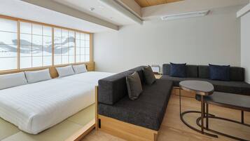 A modern room with a bed, sofa, and a small table.
