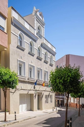 Un edificio de varios pisos con fachada simétrica, ventanas amplias y una entrada central.