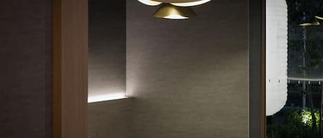 A modern bathroom with a wooden vanity, a round mirror, and a pendant light fixture.