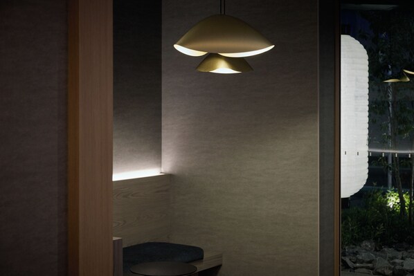 A modern bathroom with a wooden vanity, a round mirror, and a pendant light fixture. - Premium MONday ASAKUSA II (Tokyo)