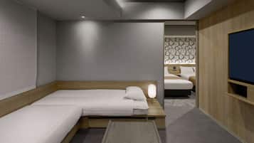 A hotel room with a bed, bedside table, lamp, and a TV.