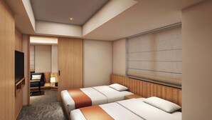 A hotel room with two beds, a desk, a TV, and a large window with blinds.