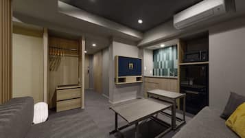 Una habitación moderna y luminosa con televisor incorporado, microondas y una pequeña kitchenette.