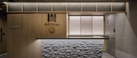 A reception desk with a wooden panel and a stone-textured counter.