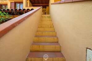 Een trap met aan weerszijden een beige muur en een houten leuning.