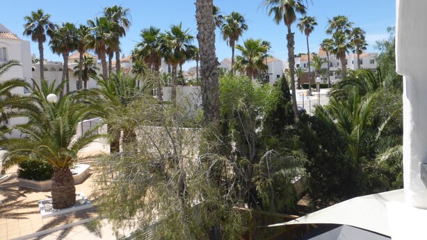 A courtyard with palm trees, a pool, and white buildings. - Lovely 1-bedroom Apartment in Roquetas de Mar, Spain (Roquetas de Mar)