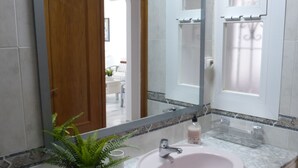 A bathroom with a marble sink, a mirror, and a potted plant. - Lovely 1-bedroom Apartment in Roquetas de Mar, Spain (Roquetas de Mar)