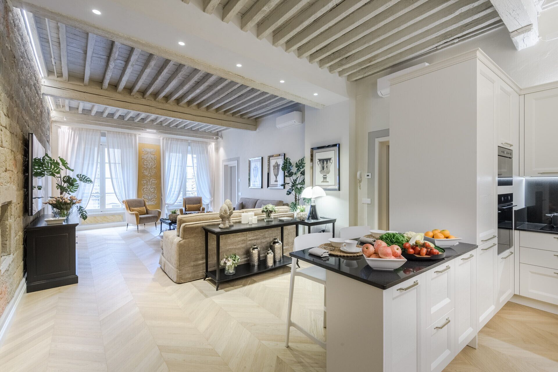 A spacious living area with a kitchen island, a dining table, and a sofa.